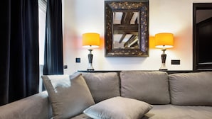 A modern living room with a beige sofa, two lamps, and a decorative mirror on the wall. - Stay U-nique Apartments Carretes (Barcelona)