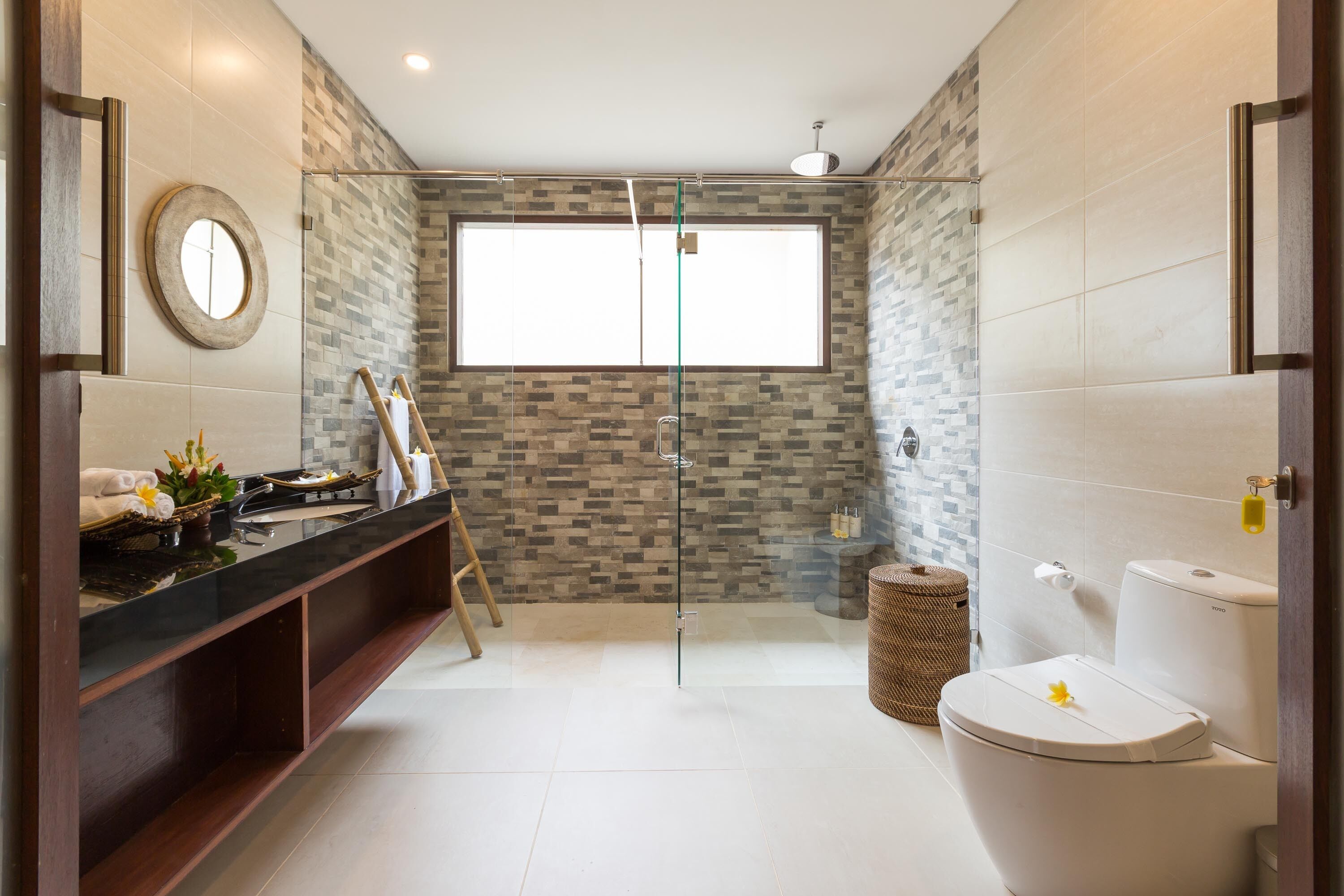 A modern bathroom with a glass shower enclosure, a toilet, and a vanity with a sink.