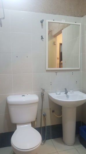 A bathroom with a toilet, a sink, and a mirror. - Hotel Fujisan PWTC (Kuala Lumpur)