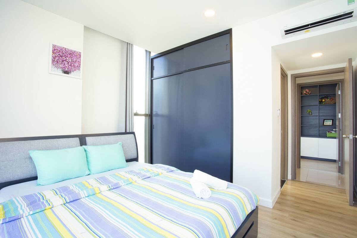 Una habitación de hotel moderna con cama, armario y una pequeña kitchenette.