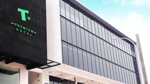 A modern hotel building with a prominent 'T+' logo and 'PREMIUM HOTEL' signage. - T+ Premium Hotel (Alor Setar)
