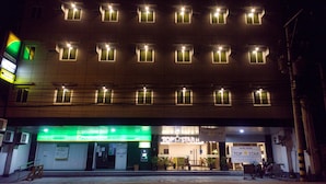 Un hotel con varios pisos, un cartel verde de un banco y un cartel del Hotel Top Star.