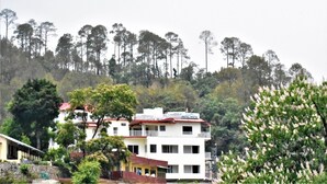 A multi-story building with balconies, surrounded by trees and vegetation. - Hotel Vista (Nainital)