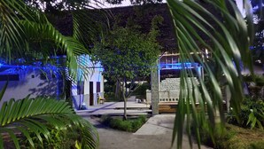 A pathway leading to a building with a stone facade and blue lighting. - Kintana Hotel (Nosy Be)