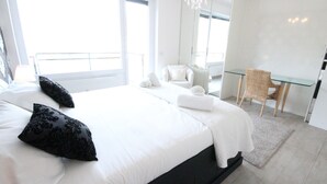 A modern hotel room with a large bed, a desk, a chair, and a balcony. - Victoria Apartment (Como)