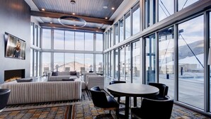 A spacious hotel lobby with a large seating area, a round table, and a fireplace.