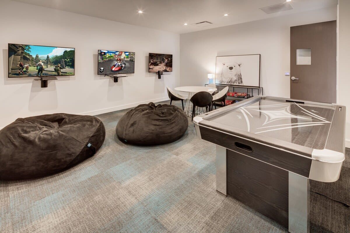 A modern room with a ping pong table, bean bags, and wall art.