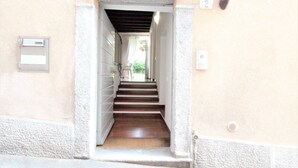 Eine schmale Treppe führt zu einer Zwischenebene mit einer Tür rechts.