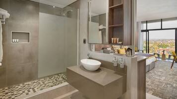 A modern bathroom with a large mirror, a white sink, and a shower area.