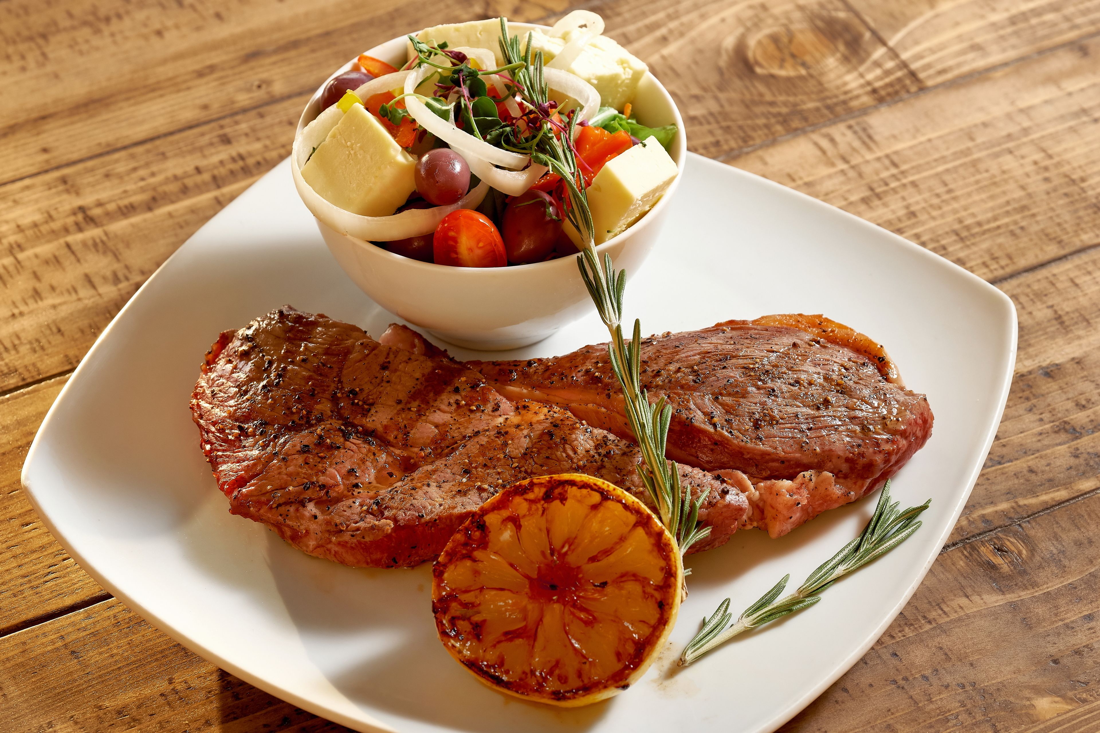 Prato com bife grelhado e uma salada.