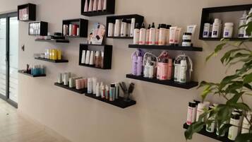 Una pared con múltiples estantes negros que exhiben varios productos para el cuidado de la piel.