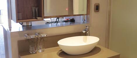 A modern bathroom with a large mirror, a vessel sink, and a towel rack.