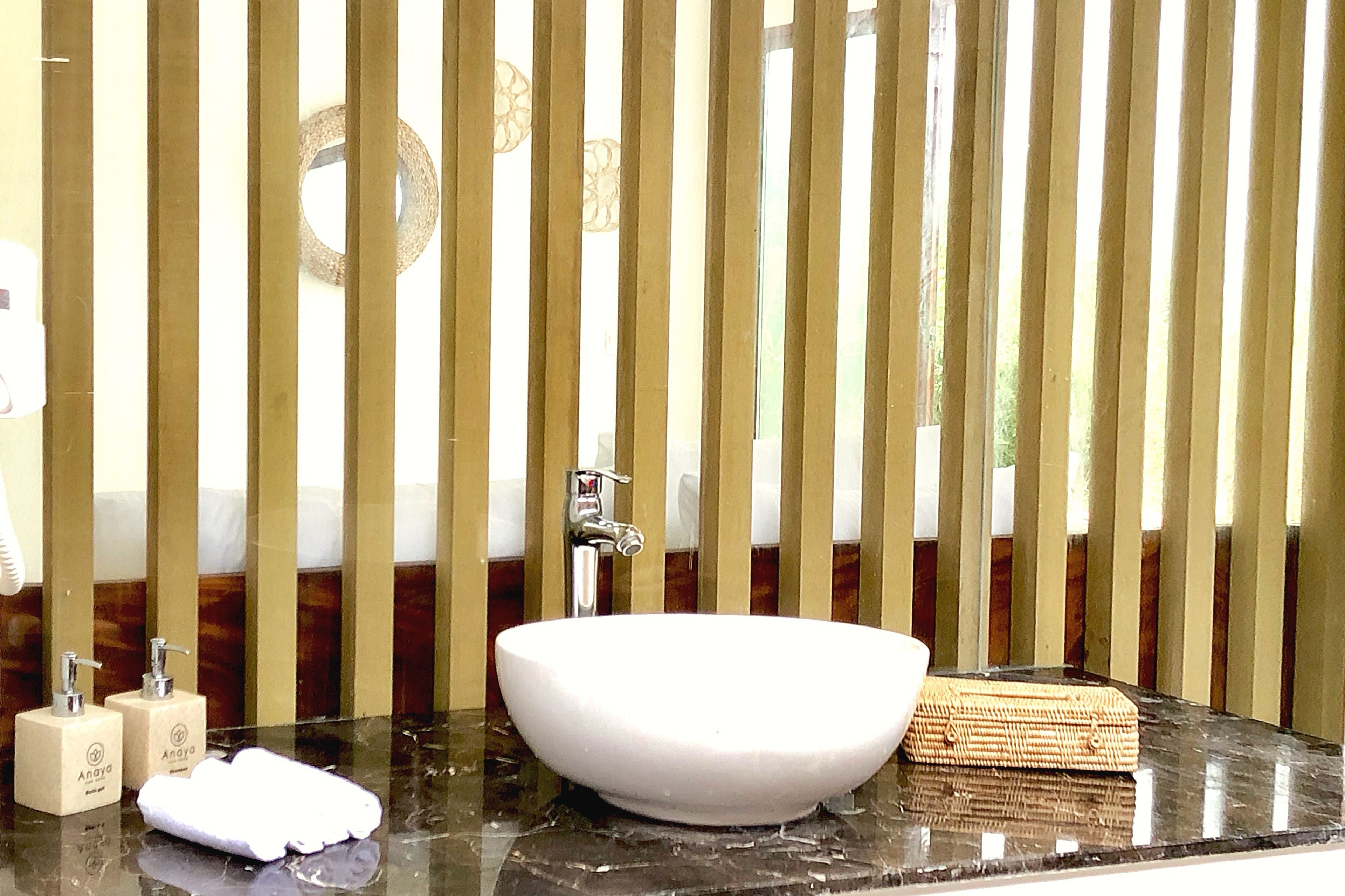 A bathroom with a white sink, a mirror, and a towel rack.