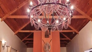 Un salon avec un plafond en bois, une cheminée et deux fauteuils.