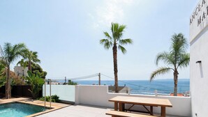 A rooftop terrace with a pool, palm trees, and a view of the sea. - Luxury villa with private pool and sea view (ANCLA MAR nº5) (Roses)