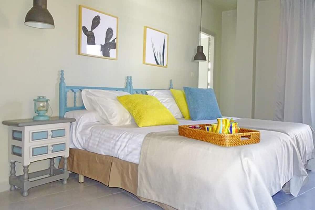 Een slaapkamer met een bed, nachtkastjes en kunstwerken aan de muren.