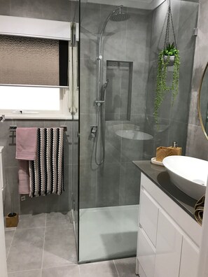 Enjoy a refreshing shower in the sleek bathroom with a glass-enclosed shower and wall-mounted faucet.