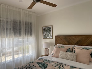 A bedroom with a bed, a ceiling fan, a window with sheer curtains, and a wall-mounted lamp. - McCrae beach Villa on Wattle Place, a 5 mins walk to the beach (McCrae)