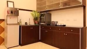 Eine kleine Küche mit Kühlschrank, Mikrowelle und einem Schrank mit Glastür.