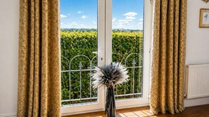 A room with a large window, a radiator, and a decorative vase. - Juliet Cottage - Sleeps up to 3 - Large Hot Tub (Stratford upon Avon)
