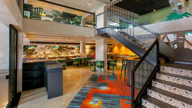 A multi-level interior with a staircase, dining area, and a kitchen. - Ginger Goa Madgaon (Margao)