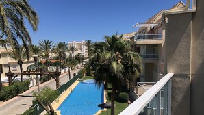 Zona residencial amb piscina, palmeres i un carrer.