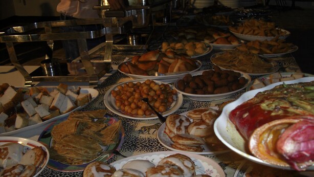 A buffet with various dishes including pancakes, pastries, and a pizza. - Lamu Sunsail Hotel (Lamu)