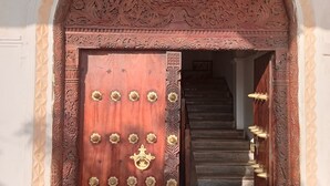 An ornate wooden door with a sign above reading "SUNSAIL HOTEL." - Lamu Sunsail Hotel (Lamu)
