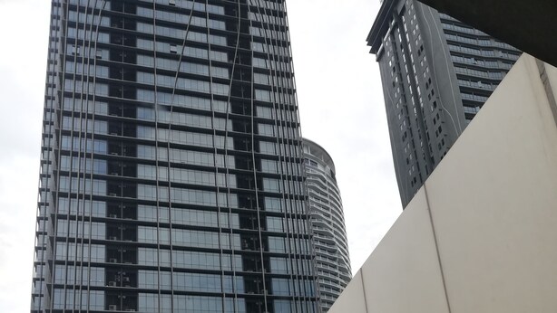 Um edifício moderno com fachada curva, janelas amplas e um logotipo destacado no topo.