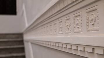 A close-up of a white architectural detail with carved patterns and a textured surface.