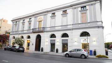 Un edificio blanco con ventanas arqueadas y un letrero que dice "JPEC".