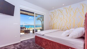 Ein Schlafzimmer mit einem Bett, einem großen Fenster und Meerblick.
