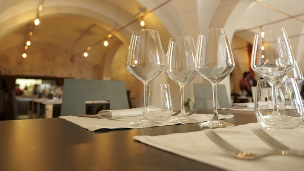 A dining table with several empty wine glasses and cutlery, set on a tablecloth. - Hotel La Smorfia (Rosignano Marittimo)