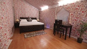 A bedroom with a wooden bed, a desk, and a chair. - Jaisalmer Khodiyar Resort - Campsite (Jaisalmer)