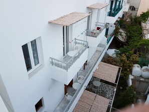 A multi-story residential building with balconies, outdoor seating, and a garden area.