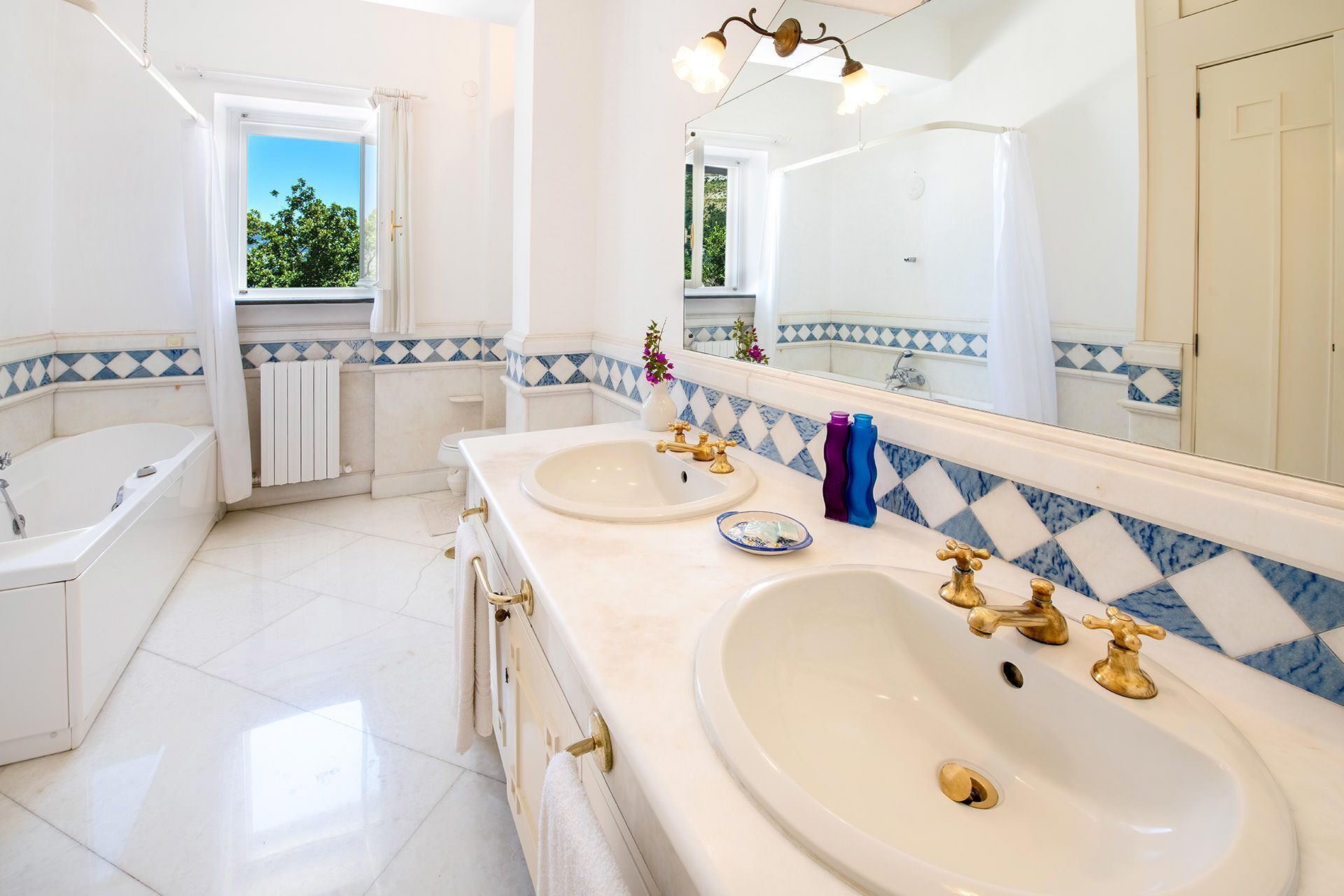 A bathroom with two sinks, a bathtub, and a large mirror.