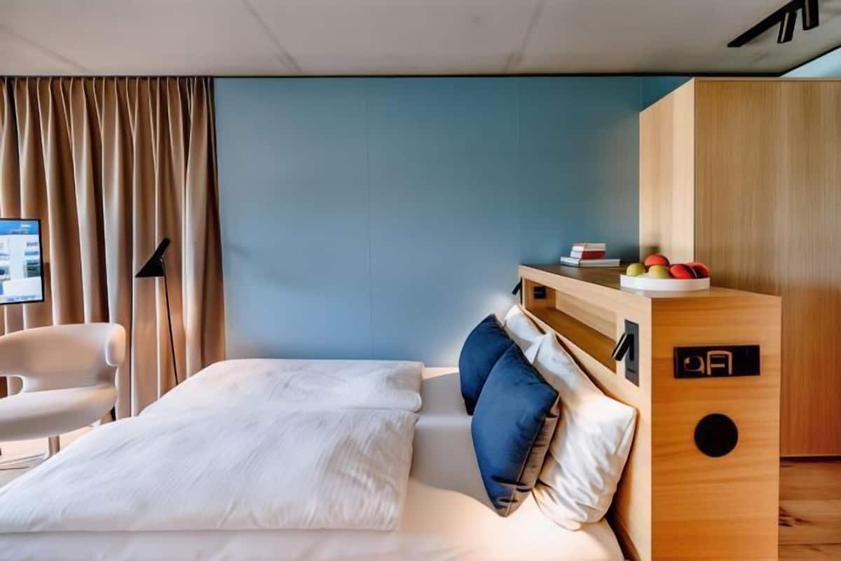 Luxe beddengoed, een kluis op de kamer, een bureau, een laptopwerkplek