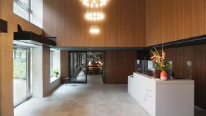 Un intérieur moderne avec un comptoir d’accueil, de grandes fenêtres et un lustre original.