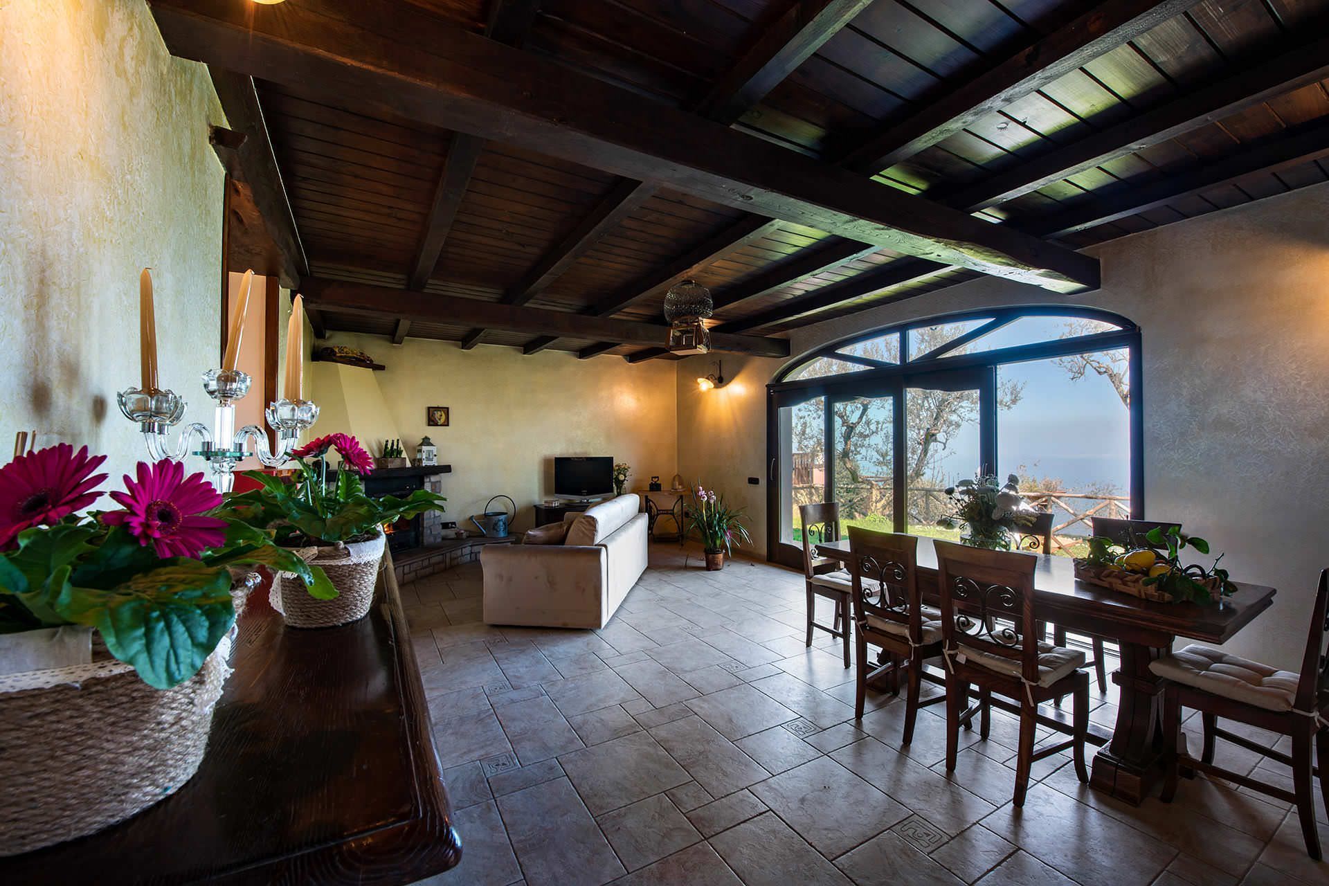 Una sala de estar acogedora con chimenea, televisión y comedor con muebles de madera.