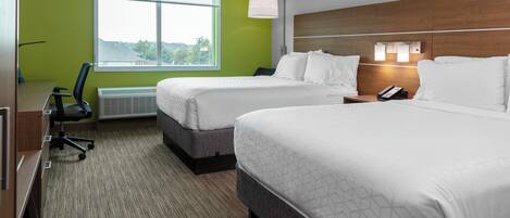 A hotel room with two beds, a desk, and a chair.