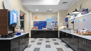 A modern hotel kitchen with a self-service breakfast station, a bakery, and a coffee machine. - Holiday Inn Express & Suites Leander by IHG (Leander)