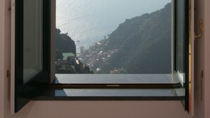 Una ventana con vistas a un pueblo costero y al mar.
