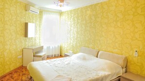 A hotel room with a bed, bedside tables, a desk, and a mirror. - Description of Staroreznichnaya 28 (Odessa)