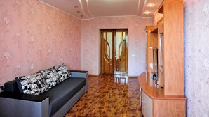 A room with a sofa, a wooden cabinet, and a patterned wall. - Description of Staroreznichnaya 28 (Odessa)