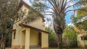 A two-story building with a tiled roof and a small porch. - Pousada Casa Da Trilha (Palmeiras)