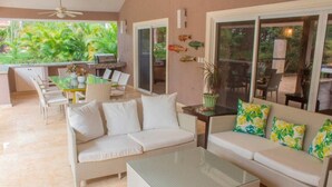 A spacious living area with a sofa, a coffee table, and a dining table with chairs. - Exquisite Taste Awaits you With This Custom Styled Villa (Sosúa)