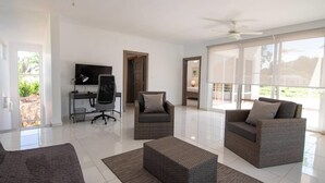 A spacious living room with a flat-screen TV, a desk, and two sofas. - Private 3 Bedroom Villa Near Walking Trail (Sosúa)