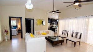 A spacious living area with a white sofa, a coffee table, and two chairs. A ceiling fan and chandelier are visible. - Private and Spacious 5 Bedroom Villa (Sosúa)