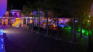 A hotel courtyard with a pool, palm trees, and a staircase leading to the upper floors. - Luxury 14 Bedroom Villa Walking to Clubs/beaches! (Sosúa)