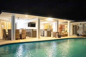 Un área interior de piscina moderna con cocina y zona de estar.